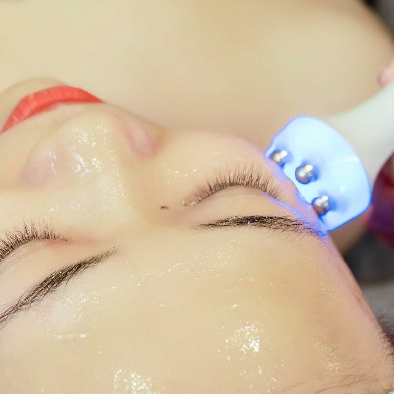 Close-up of a woman receiving an ultrasonic facial treatment in a spa in Hanoi, Vietnam.